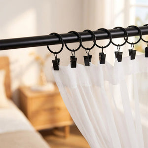 Anneaux de rideau noirs ouvrants avec un voilage blanc dans une chambre lumineuse