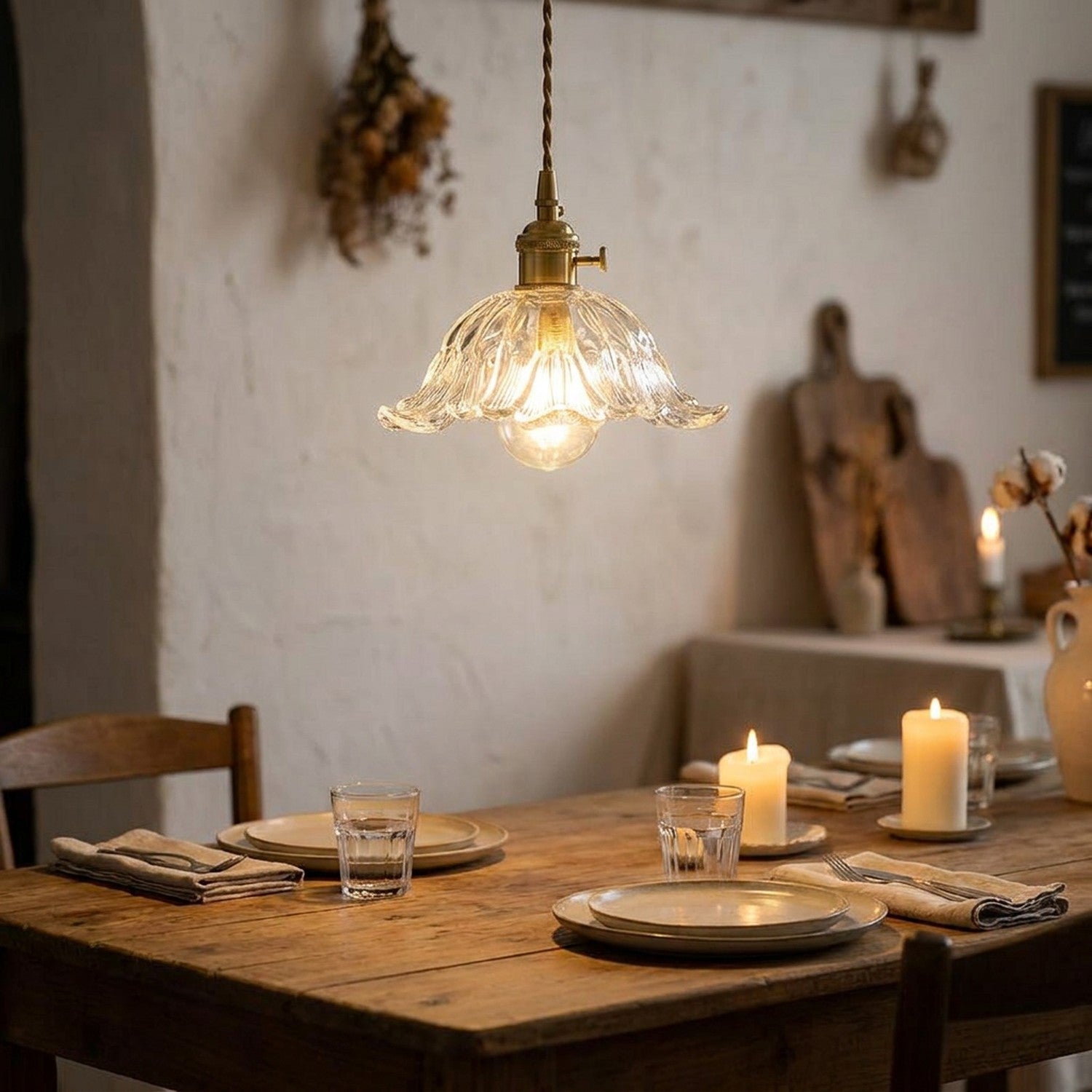 Suspension florale en verre éclairée au-dessus d'une table à manger rustique ambiance bougies