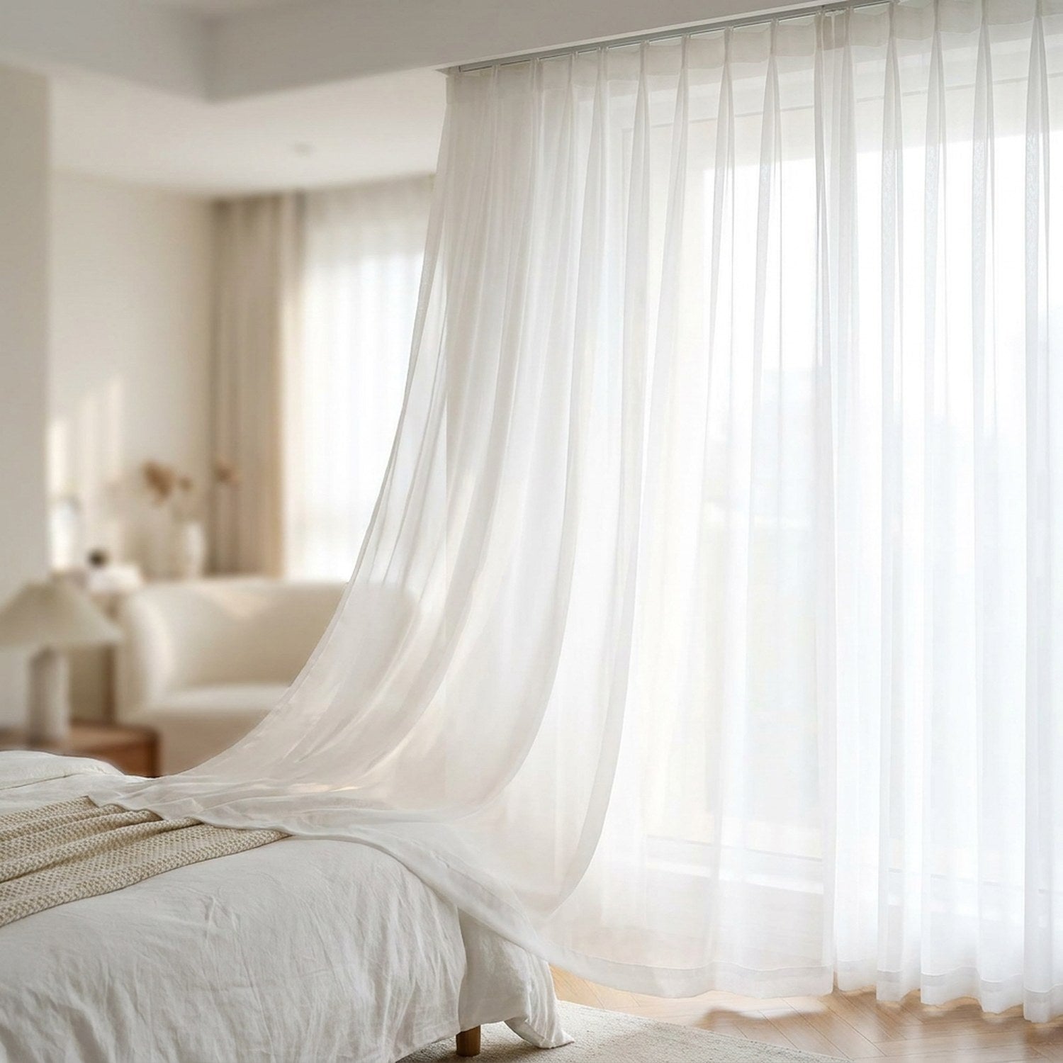 Voilage blanc plis en S suspendu à une fenêtre de chambre lumineuse