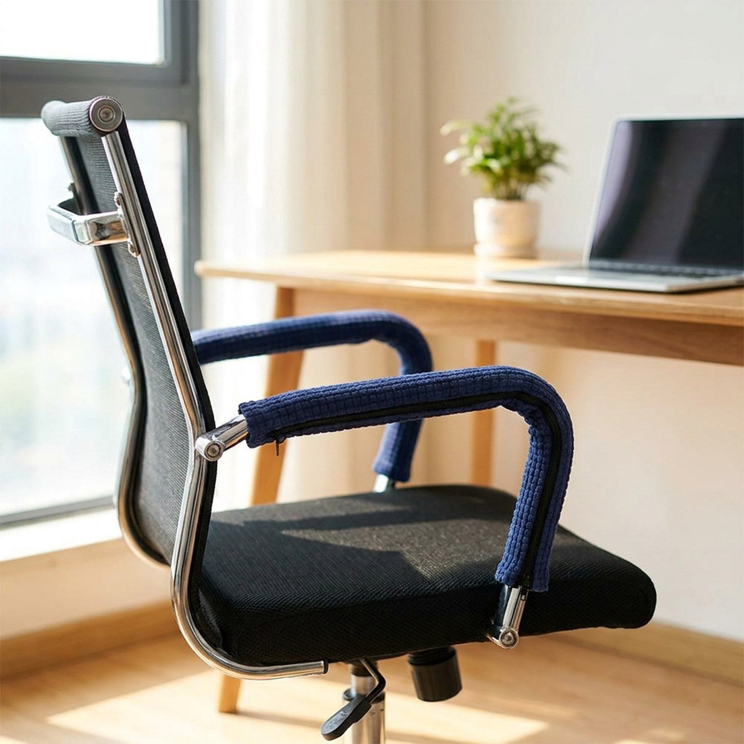 Chaise de bureau avec housses d'accoudoir bleu marine près d'une fenêtre lumineuse