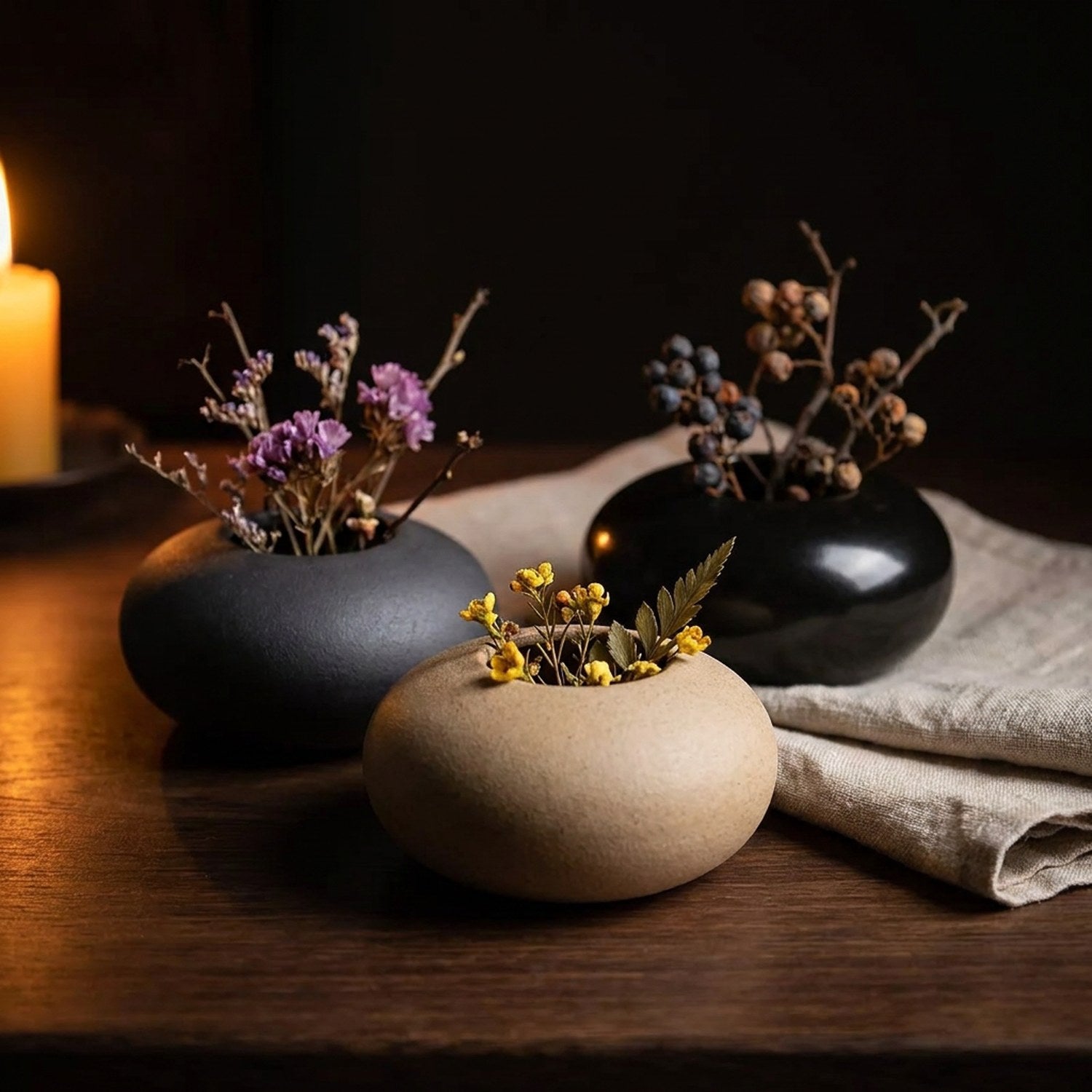 Groupe de vases céramique pebble en bois avec fleurs séchées et bougie