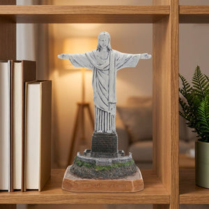 Statue du Christ rédempteur sur une étagère en bois avec livres et plante verte