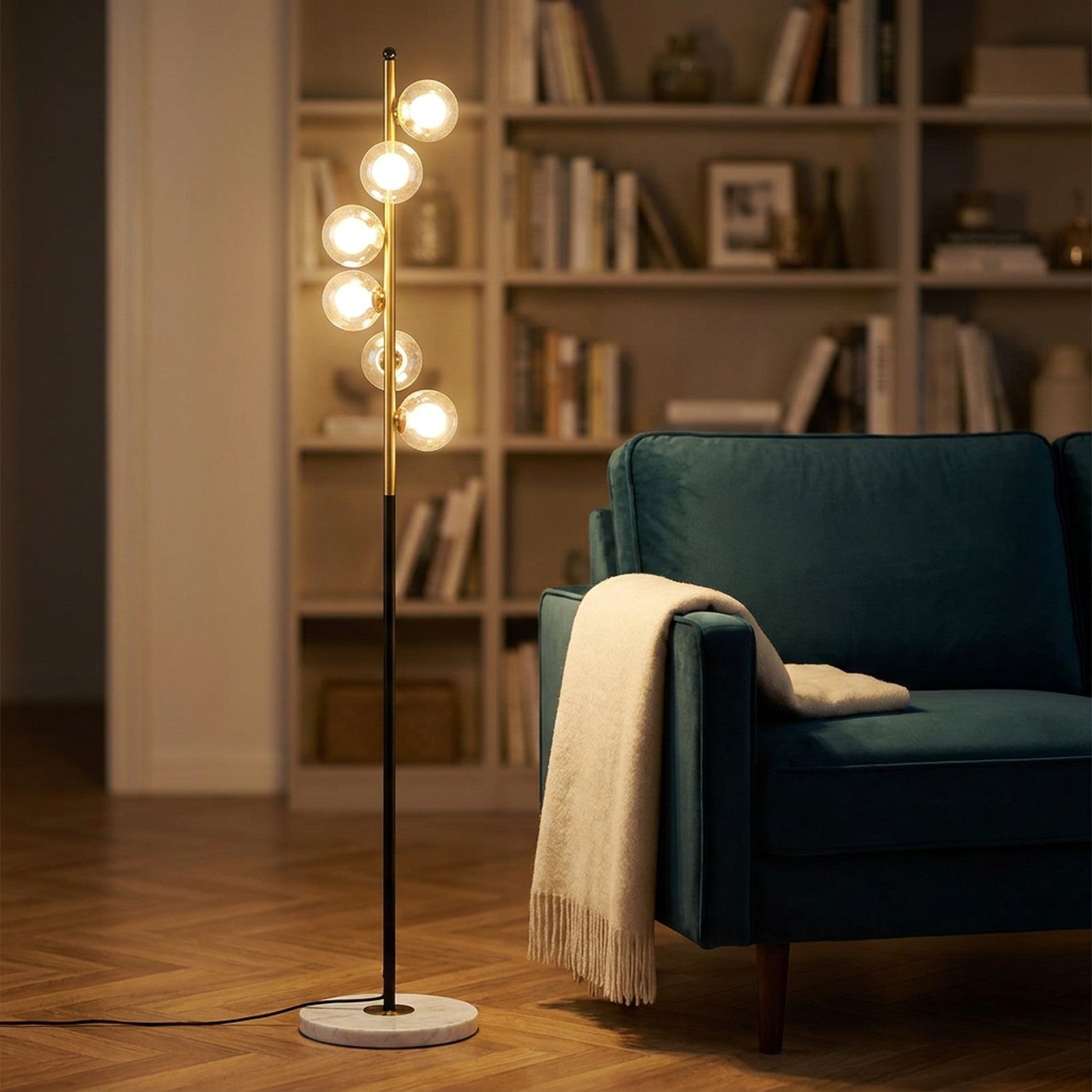 Lampadaire nordique allumé dans un salon scandinave avec canapé vert canard et bibliothèque en arrière-plan