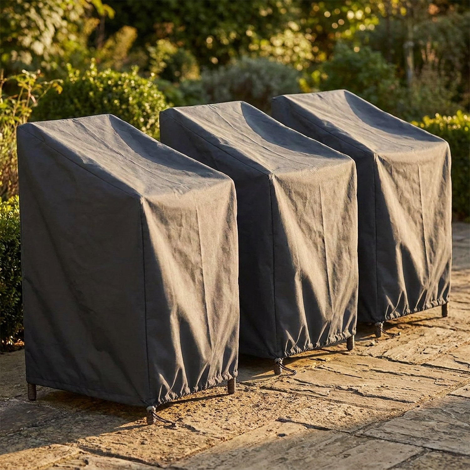 Trois housses de chaise de jardin empilables alignées sur une terrasse ensoleillée