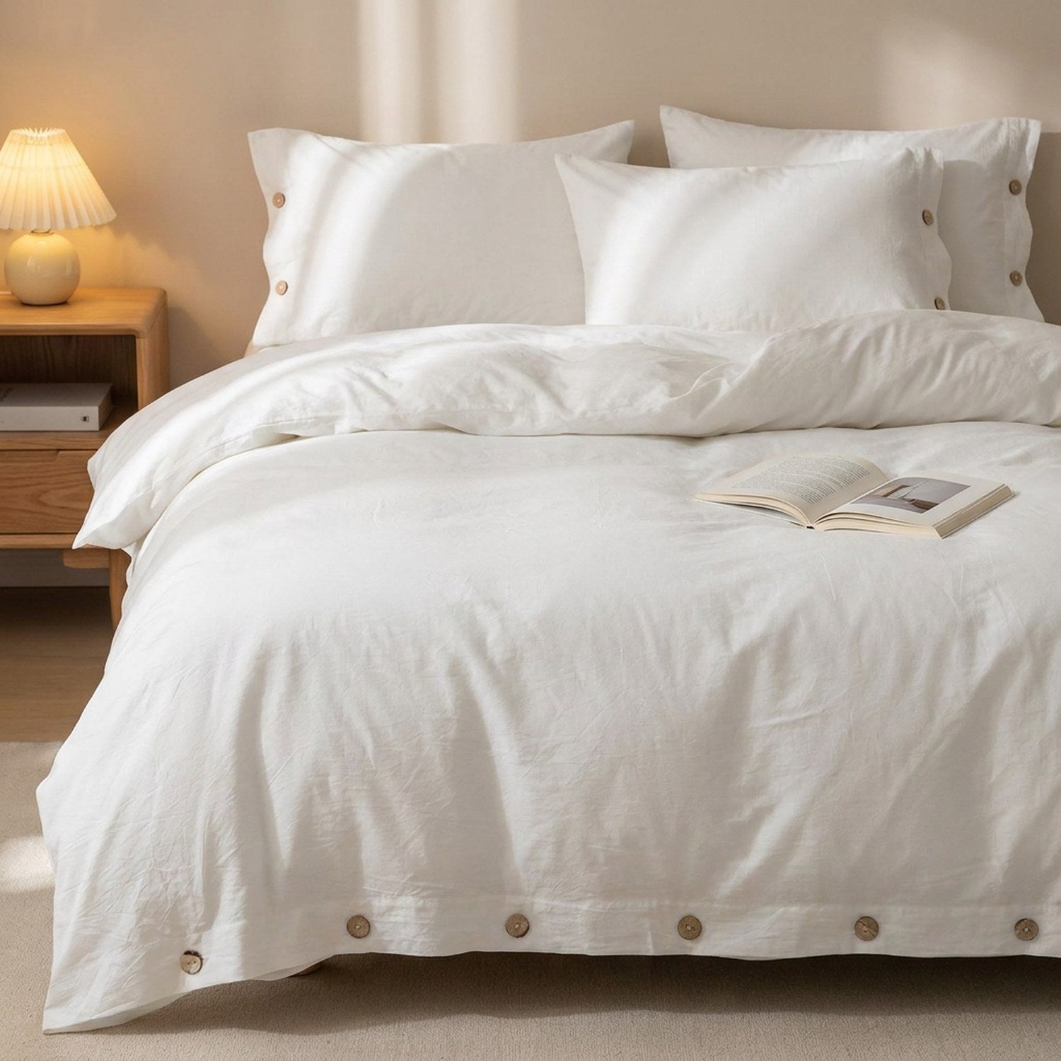 Housse de couette blanche posée sur un lit avec lampe de chevet en bois