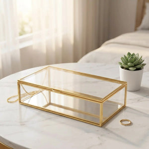 Boîte à bijoux en verre fermée sur surface marbre blanc avec petite plante grasse