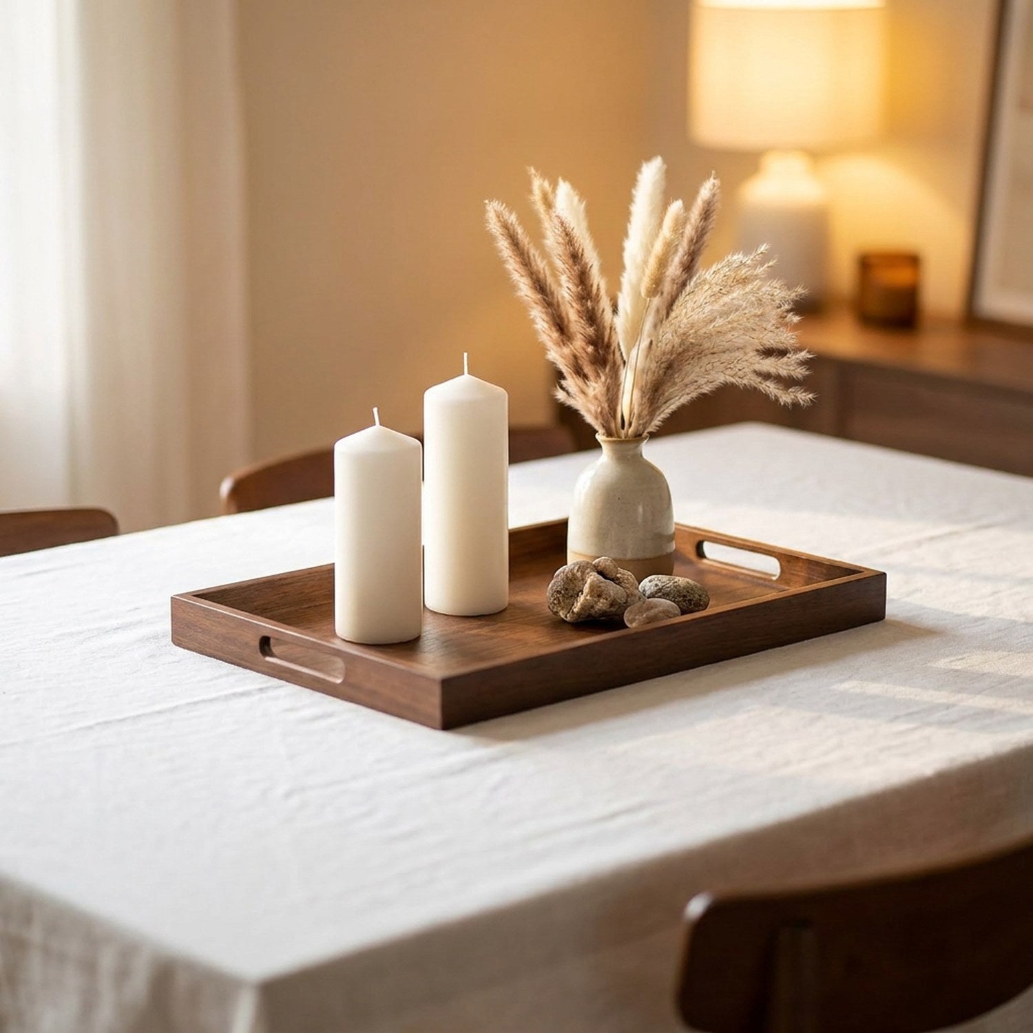 Plateau de service en bambou teinte noyer avec bougies et pampas sur table de salle à manger