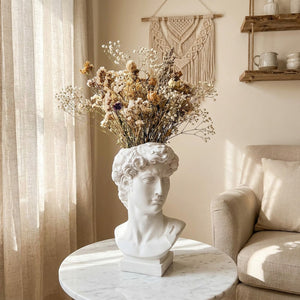 Vase buste antique avec fleurs séchées sur table marbre intérieur bohème