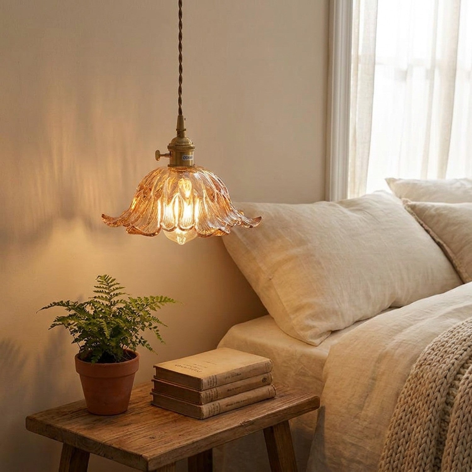 Suspension florale en verre ambré dans chambre cocooning avec table de chevet et plante