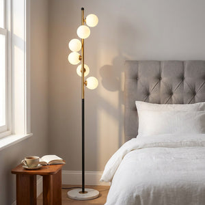 Lampadaire nordique à 5 boules de verre dans une chambre élégante avec tête de lit capitonnée