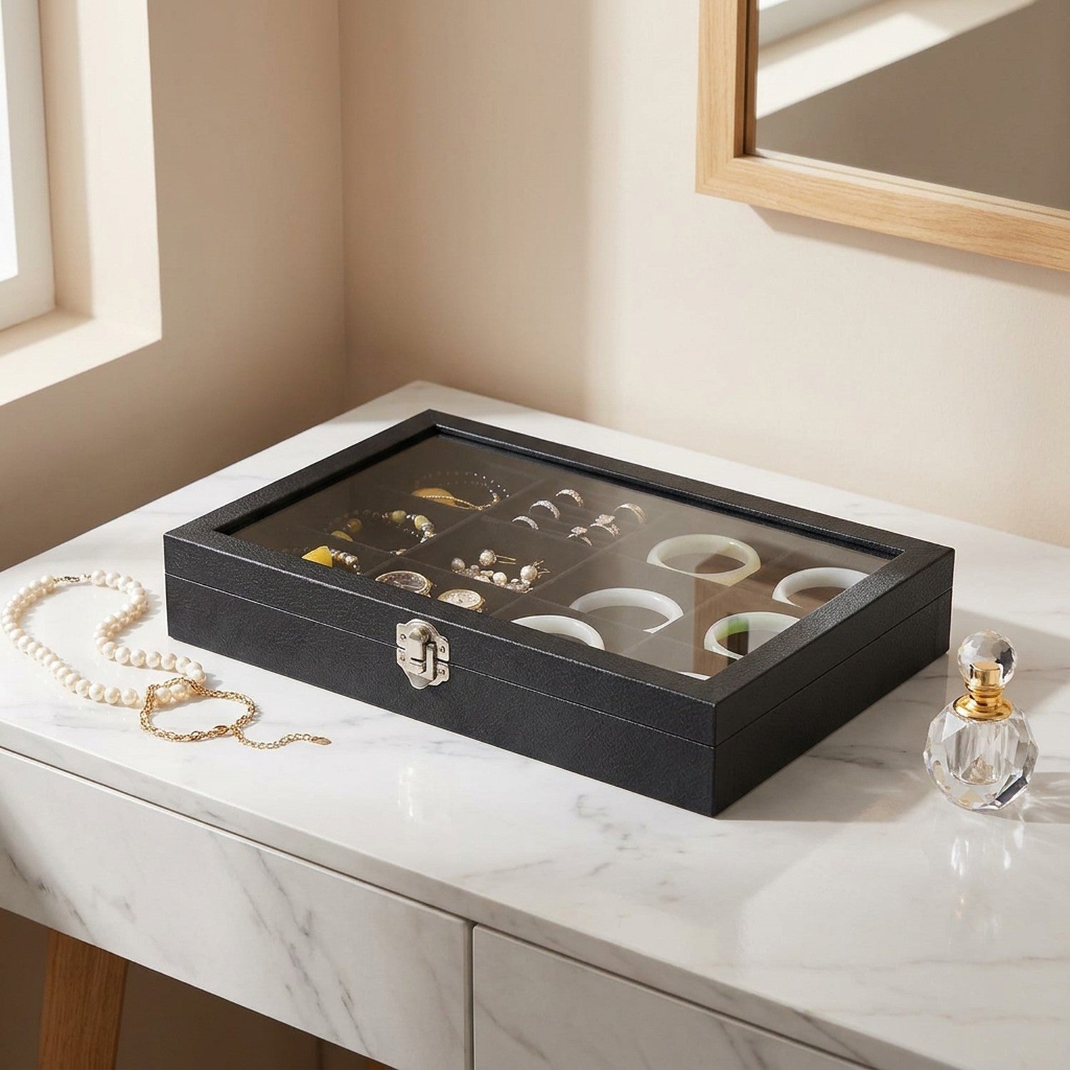 Boîte à bijoux noire couvercle en verre sur table en marbre