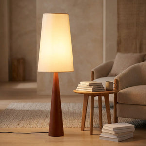 Lampadaire allumé près d'un canapé et d'une table d'appoint