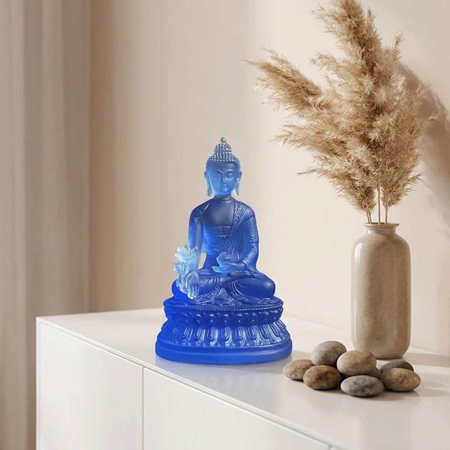 Bouddha de médecine bleu sur console blanche avec pampa et galets, ambiance boho zen