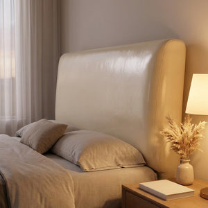 Housse de tête de lit beige dans une chambre cosy en soirée avec lampe de chevet