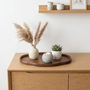 Plateau ovale bois noyer avec herbe de pampa vase et bougie sur enfilade bois style Japandi