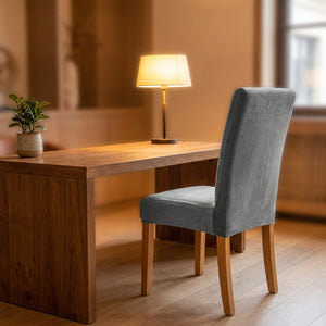 Bureau en bois avec une chaise habillée d'une housse grise en velours dans un intérieur chaleureux