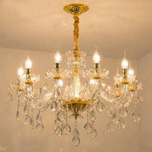 Gros plan sur le lustre baroque en cristal doré allumé sur fond chaleureux