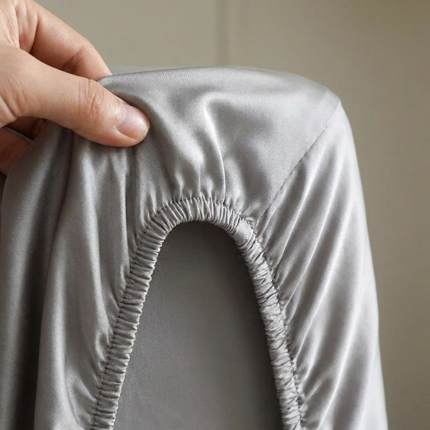 Détail de la bande élastique du drap housse en soie tirée à la main sur le coin du matelas