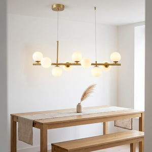 Lustre doré au dessus d'une table à manger scandinave avec banc en bois