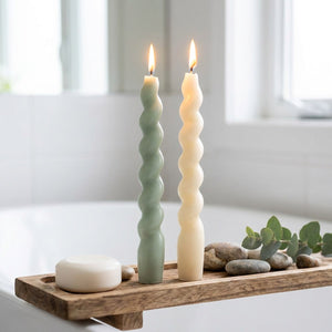 Bougies spirales allumées sur plateau bois salle de bain ambiance zen