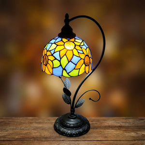 Gros plan sur l'abat-jour vitrail tournesol de la lampe allumée