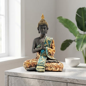 Bouddha thaï noir orné de dorures et joyaux turquoise en décoration sur une console en bois