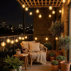 Guirlande lumineuse globe LED G40 sur balcon urban avec plantes et fauteuil rotin