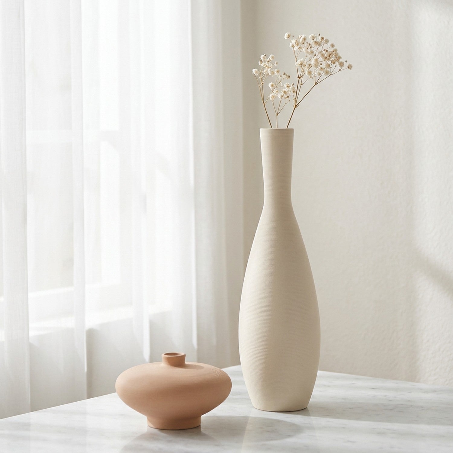 Soliflore en céramique beige avec branche de gypsophile sur surface en marbre