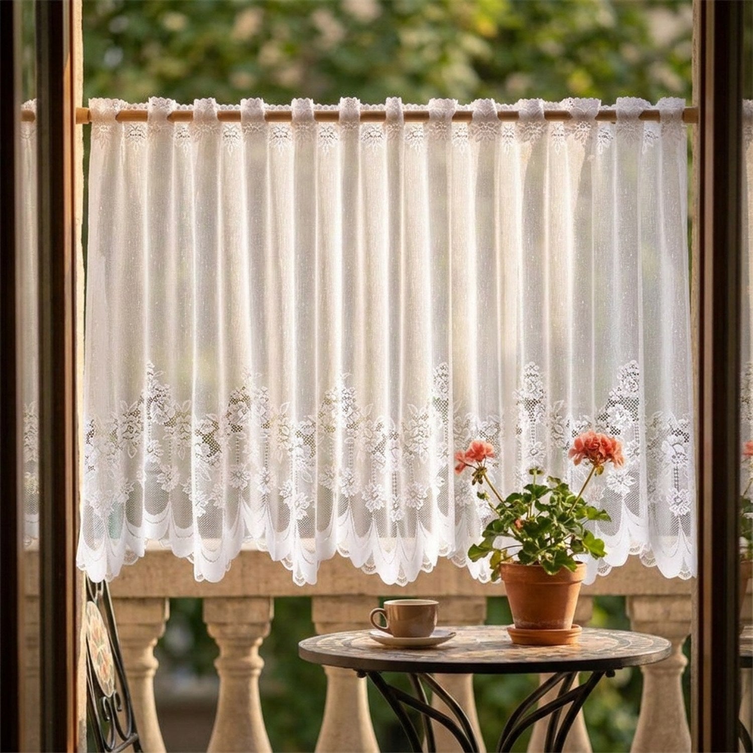 Rideau brise vue en dentelle sur un balcon avec table et geranium