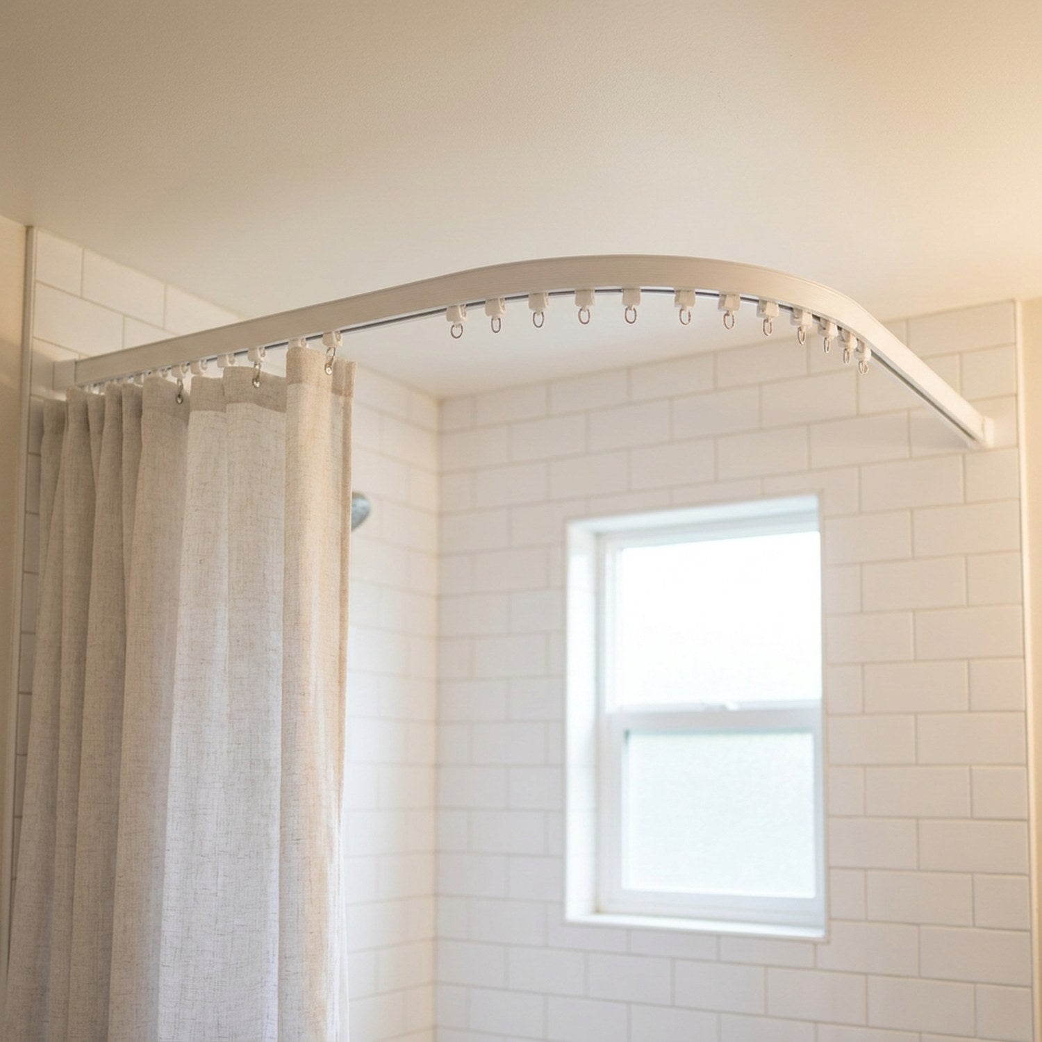 Rail de rideau incurvé au plafond d une salle de bain avec rideau de douche