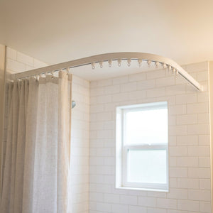 Rail de rideau incurvé au plafond d une salle de bain avec rideau de douche