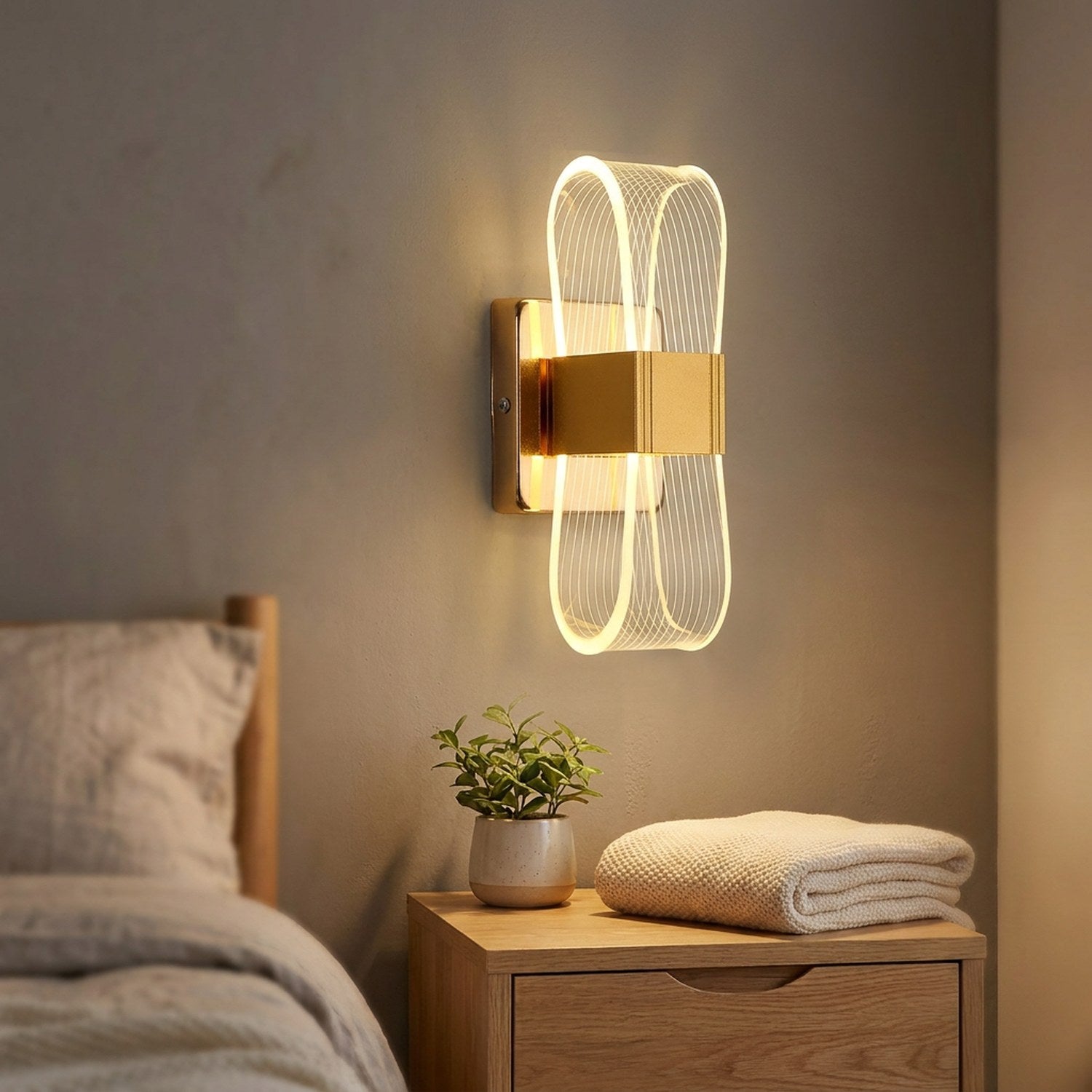 Applique murale dorée installée au-dessus d'une table de chevet en bois dans une chambre chaleureuse