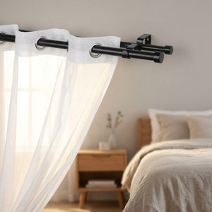 Tringle à rideau double installée dans une chambre lumineuse avec voilage blanc à œillets