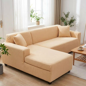 Housse de canapé d'angle beige près d'une fenêtre lumineuse avec plantes vertes