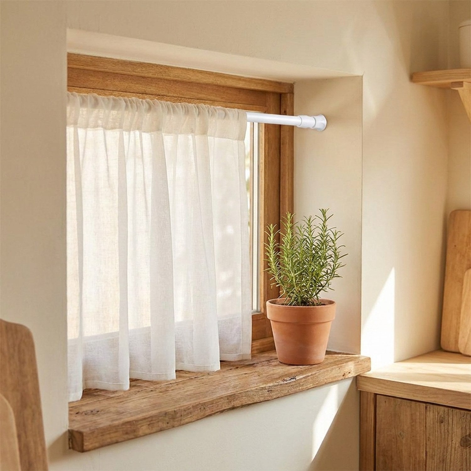 Tringle télescopique blanche à une petite fenêtre avec voilage léger et plante