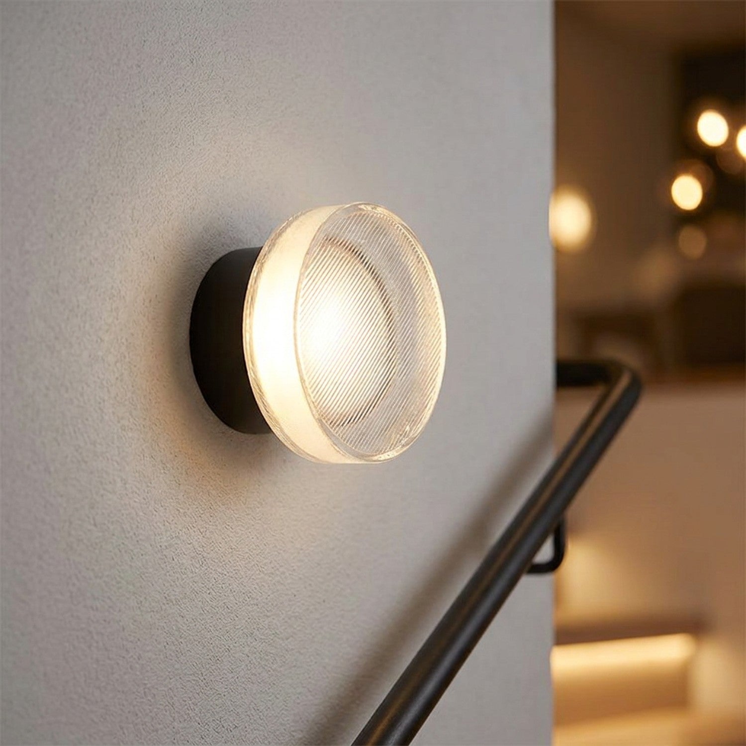 Applique murale LED noire au verre strié près d'un escalier moderne