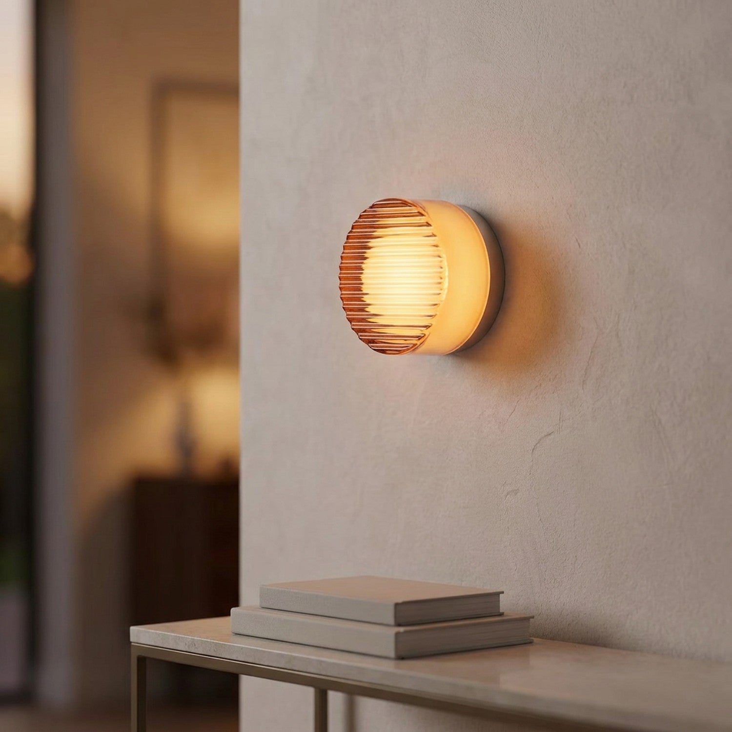 Applique murale LED orange côtelée dans une entrée près d'une console et de livres