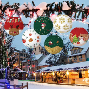 Lanternes de Noël suspendues à des branches de sapin sous la neige