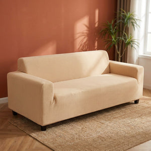 Housse de canapé beige sur canapé droit devant un mur terracotta chaleureux