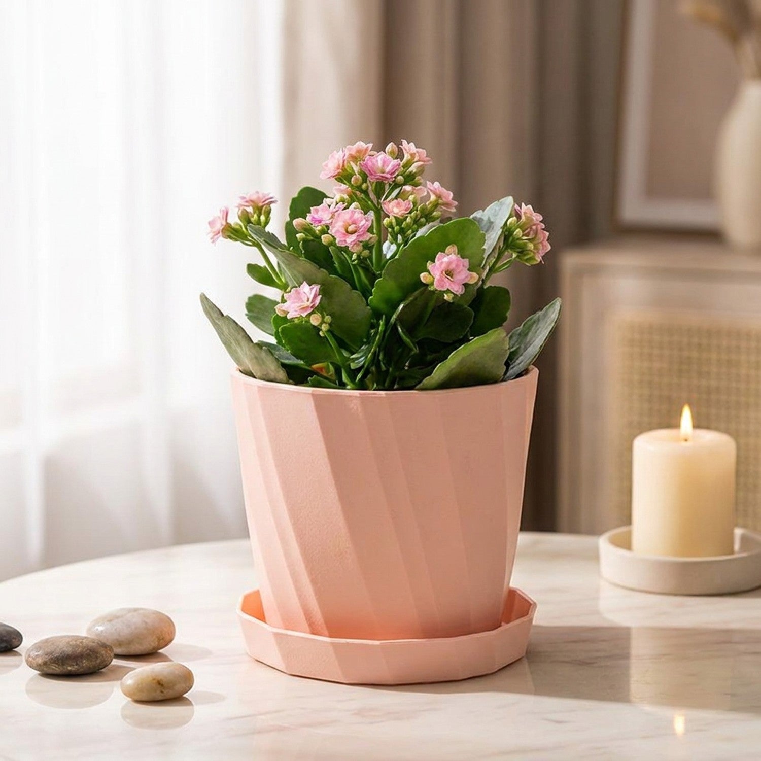 Cache-pot décoratif rose nervuré avec plante kalanchoé posé sur marbre
