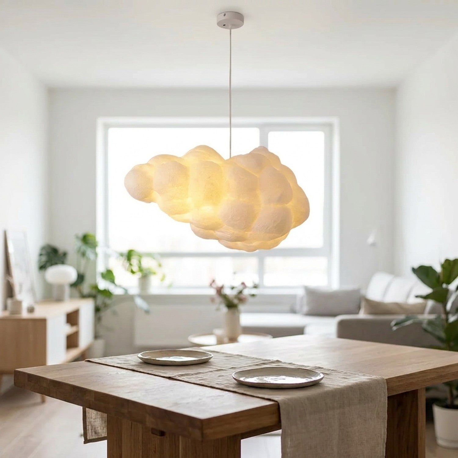 Suspension nuage blanche LED allumée au-dessus d'une table à manger scandinave