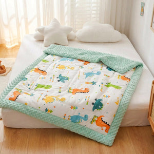 Couette bébé motif dinosaures installée sur un lit dans une chambre chaleureuse