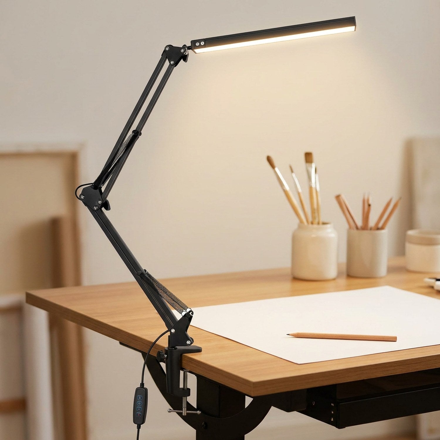 Lampe de bureau architecte noire clampée sur une table à dessin