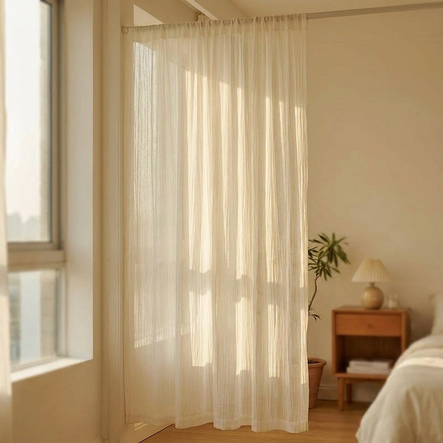 Rideau voilage blanc dans une chambre cosy avec table de chevet en bois et lumière du matin