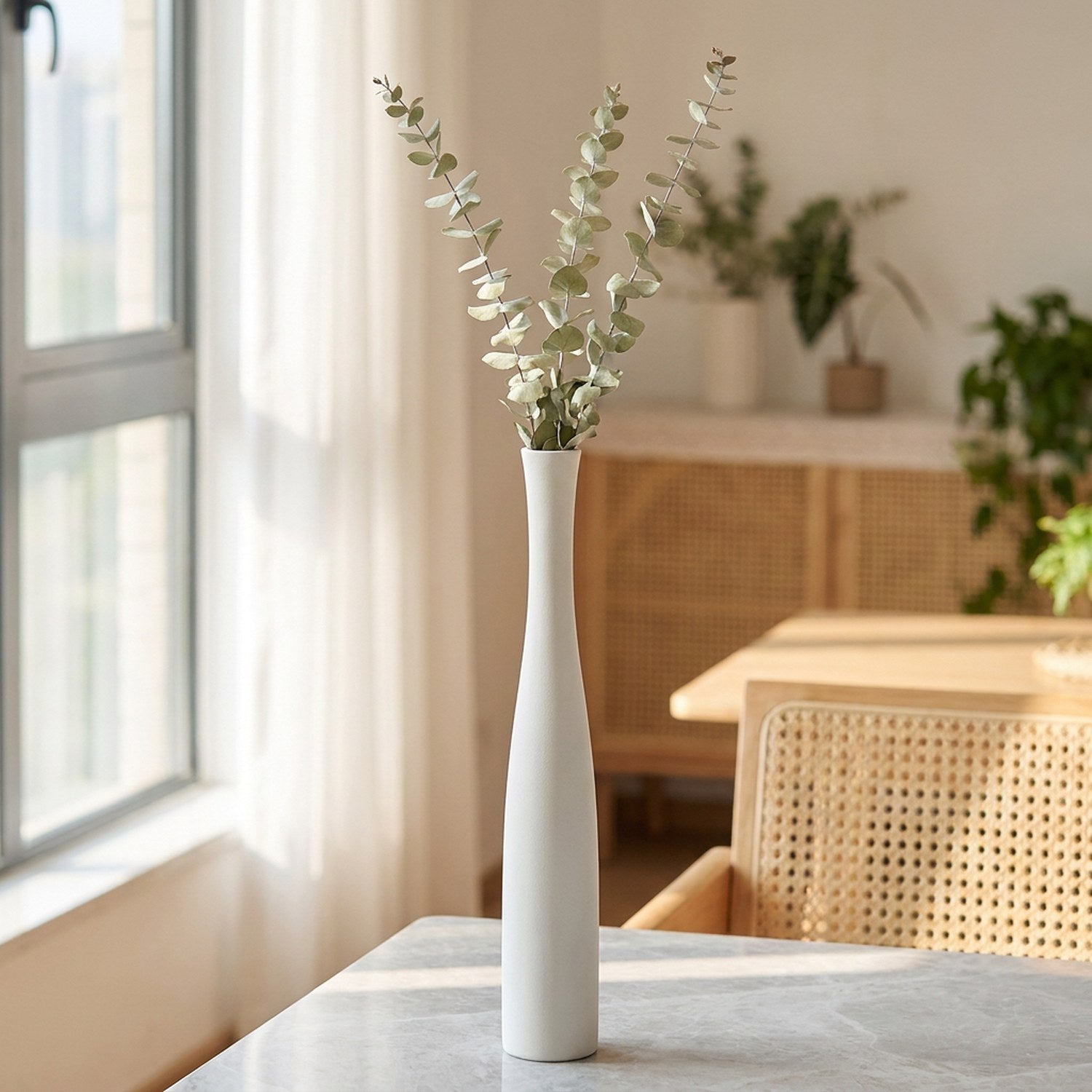 Vase soliflore blanc céramique avec eucalyptus dans un intérieur scandinave