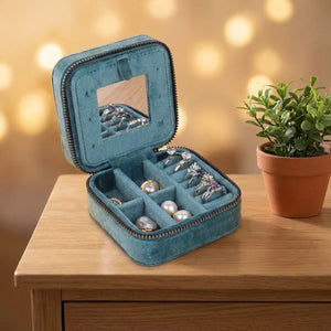 Boîte à bijoux ouverte sur une commode en bois montrant miroir et compartiments à bagues