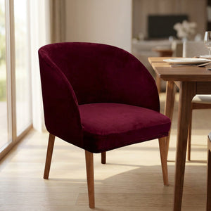 Housse de chaise velours bourgogne dans une salle à manger élégante près d'une table en bois