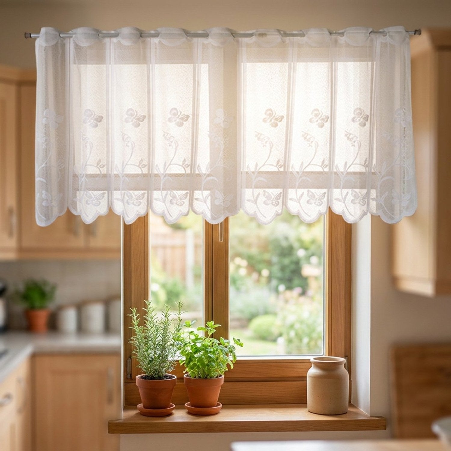 Voilage en dentelle blanche installé au-dessus d'une fenêtre de cuisine avec plantes aromatiques