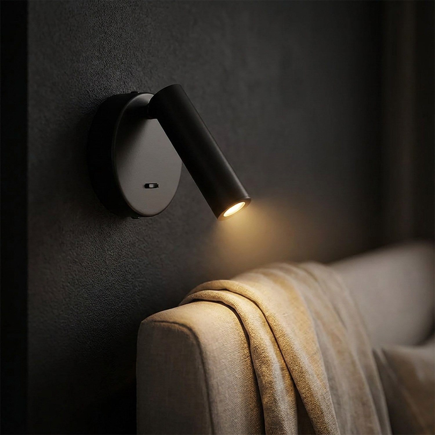Applique murale ronde noire en gros plan avec plaid beige et lumière chaude tamisée