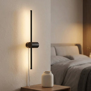 Applique murale barre rotative noire près d'un lit avec vase en céramique sur table de chevet